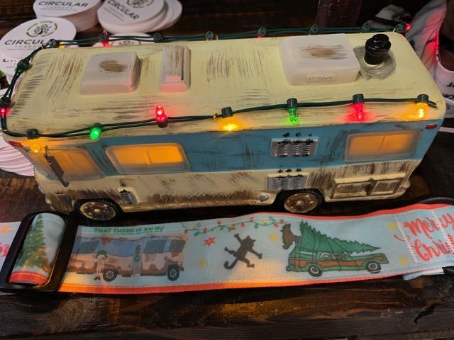 Photograph of Christmas Vacation dog collar next to a toy RV of Cousin Eddie